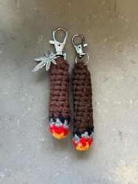 a pair of crocheted keychains with leaves on them